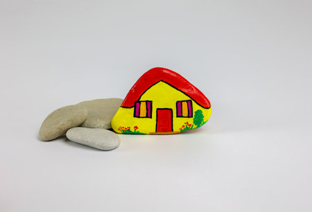 close view of painted stone as home isolated on white background, copy spaceの写真素材