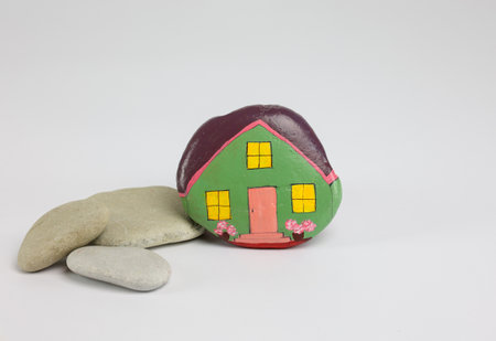 homemade painted stone as home with acrylic colors and natural stones, copy spaceの写真素材