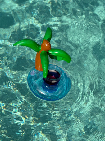 fresh glass or drink floating in a funny inflatable on a pool waterの写真素材