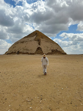 woman walking towards the bent pyramid of snefru in dashur. Egypt