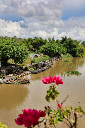 canal on Mekong delta landscape with boat decorated with flowers on a riverbank, Vietnamの写真素材
