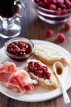 Crostini with fresh cheese, tomato jam and prosciutto, selective focusの写真素材