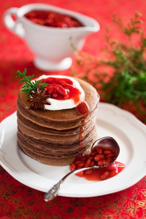 Chocolate pancakes with spiced and goji berries sauce, selective focusの写真素材