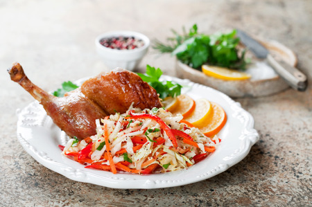 Salad of cabbage, carrots, peppers, apples and roasted duck leg, selective focusの写真素材
