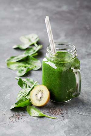 Healthy green smoothie with spinach, kiwi and chia seeds in a jar mug, selective focusの写真素材