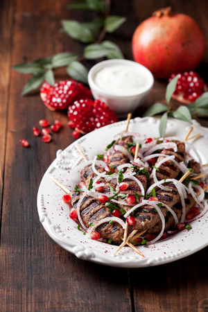 Grilled minced meat skewers kebabs with onions, sumac and pomegranate, selective focusの写真素材