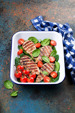 Grilled chicken fillet with tomatoes and spinach, selective focusの写真素材