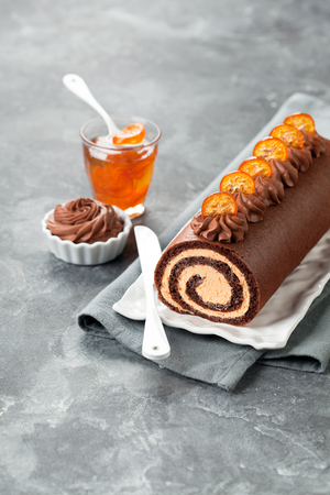 Chocolate swiss roll cake with candied kumquats, selective focusの写真素材