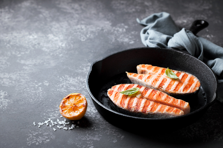 Grilled salmon steaks in cast iron pan, selective focusの写真素材