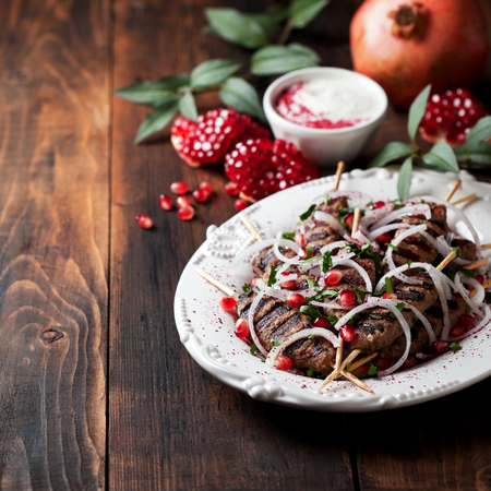 Grilled minced meat skewers kebabs with onions, sumac and pomegranate, selective focusの写真素材