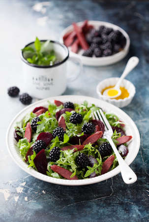 Salad with smoked sausages, beets and blackberries, selective focusの写真素材