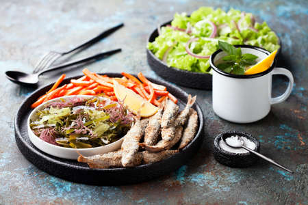Fried fish capelin, assorted seaweed salad and sweet potato fries, selective focusの写真素材