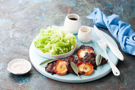 Grilled lamb heart with fried apples and fresh salad, selective focusの写真素材