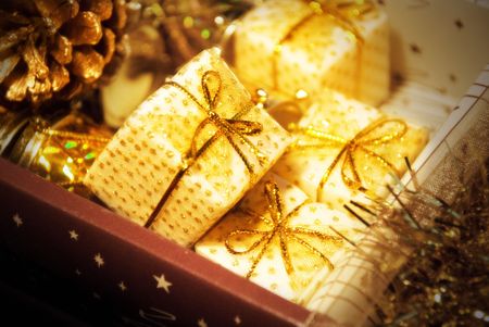 Golden gift boxes on glare background. Are tied up by tapes with bowsの写真素材