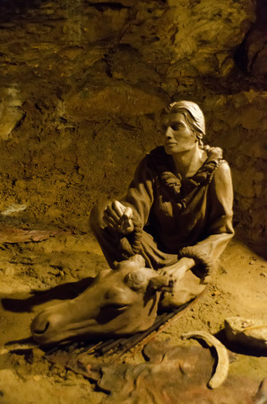 figurine of a prehistoric hunter in a caveの写真素材
