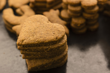 baked gingerbread in the shape of hearts poised to pile before decoratingの写真素材