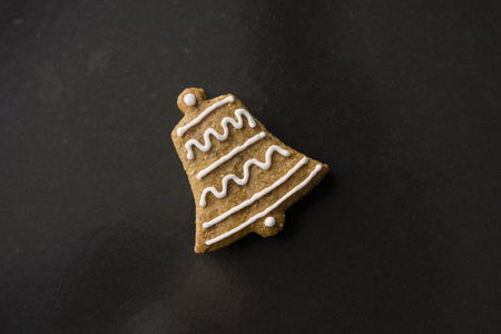 decorated gingerbread bell shape on baking sheetの写真素材