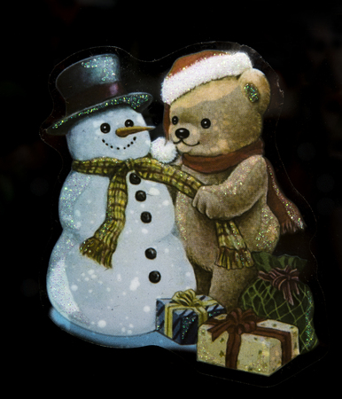 Christmas teddy bear with snowman glued to the glass as a garnishの写真素材