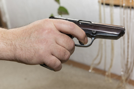 hand holding a gun with a moment before firing