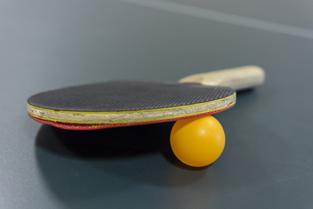 Table tennis racquet with a ball on the table.の写真素材