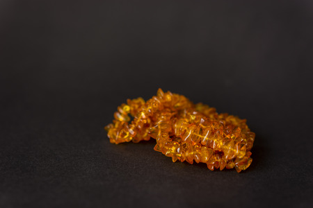 Necklace with amber pieces on a black background.の写真素材