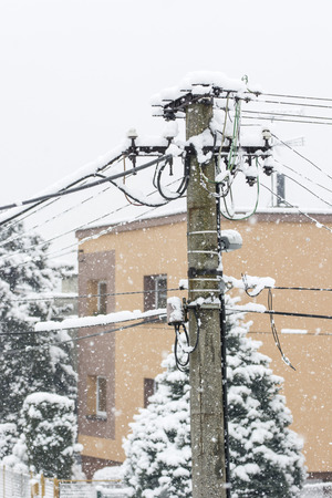 Snowy pillar and lead with house in the background.の写真素材