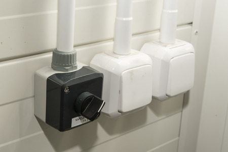 Rotary switch, classic switch and drawer with lid on the wall.