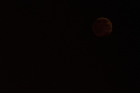A moon in the night sky during an eclipse.