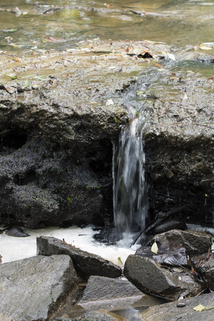 Dirty water flowing along the stone.の写真素材