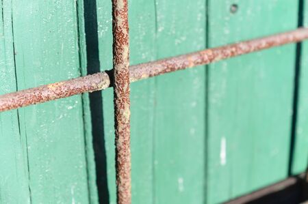 Rusty lattice near green boards. |の写真素材