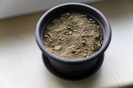 Close-up of clay in a pot on the windowsill.の写真素材