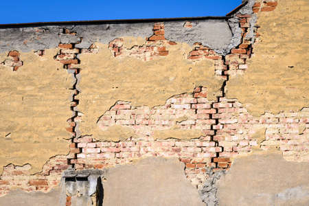 Large cracks between the bricks in the wall of the house.の写真素材