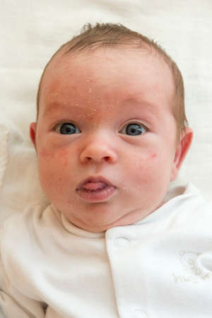 Infant crawling his tongue and lying on his back.