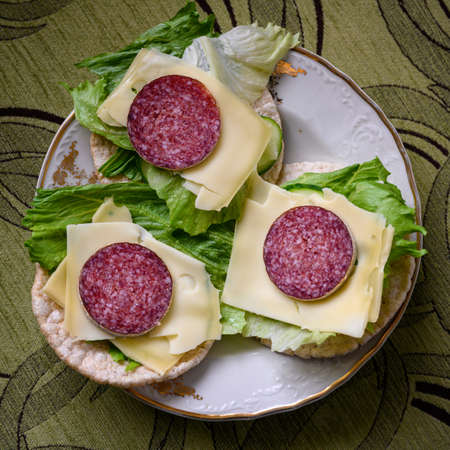 Garnished spelled pancakes with salad, slice of cheese and salami.の写真素材