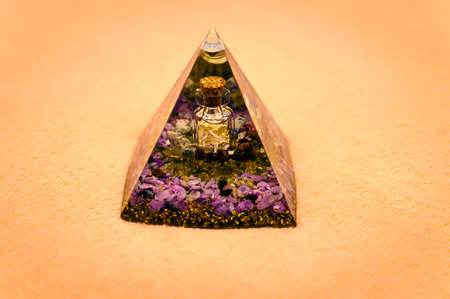 Orgonite pyramid with a bottle with silver slices.