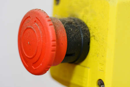 Dusty red safety button in an industrial environment.の写真素材