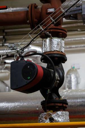 Electric pump on a hot water pipe.の写真素材