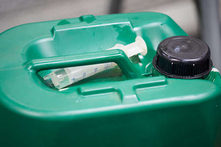 A small syringe on a barrel of oil.の写真素材