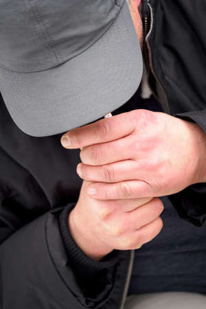 Man holding a lighted cigarette.の写真素材