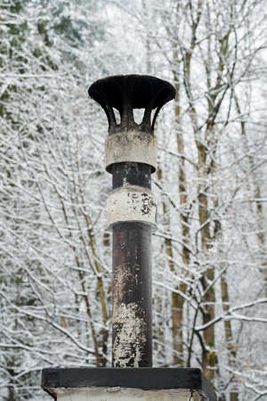 Old stone chimney in winter with snow.の写真素材