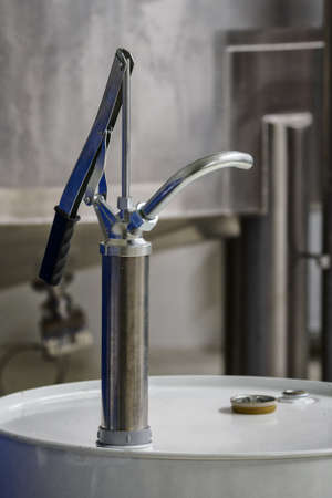 Hand pump pump lever on a metal barrel.
