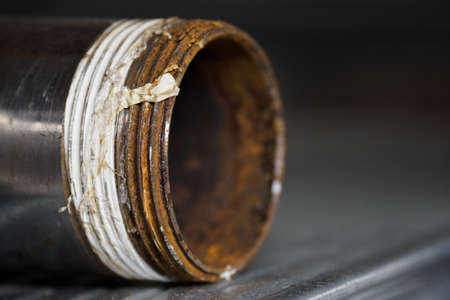 Rusty fitting on a metal pipe in detail.