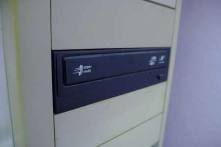 An old cd drive in the front of a desktop computer.