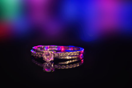 Wedding ring lying with a reflection illuminated by colors.