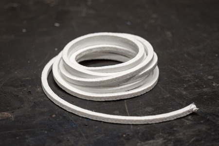 White sealing cord coiled on the workbench.