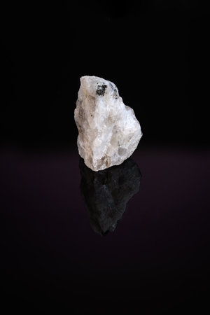 A raw moonstone fragment on a black background.の写真素材