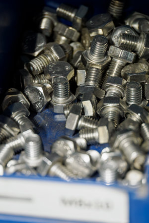 Close-up of shiny metal screws in a blue box.
