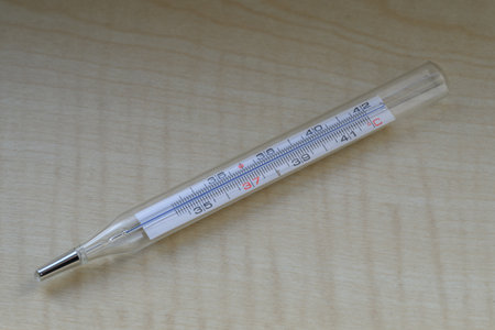 Mercury thermometer on wooden background. Thermometer equipment.