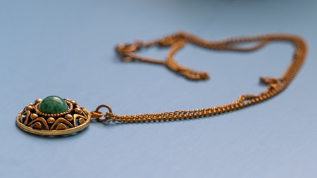 Green stone in gold brooch lying with chain.の写真素材