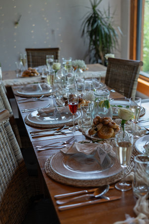 A prepared table for wedding guests with plates, glasses, and decorations.の写真素材